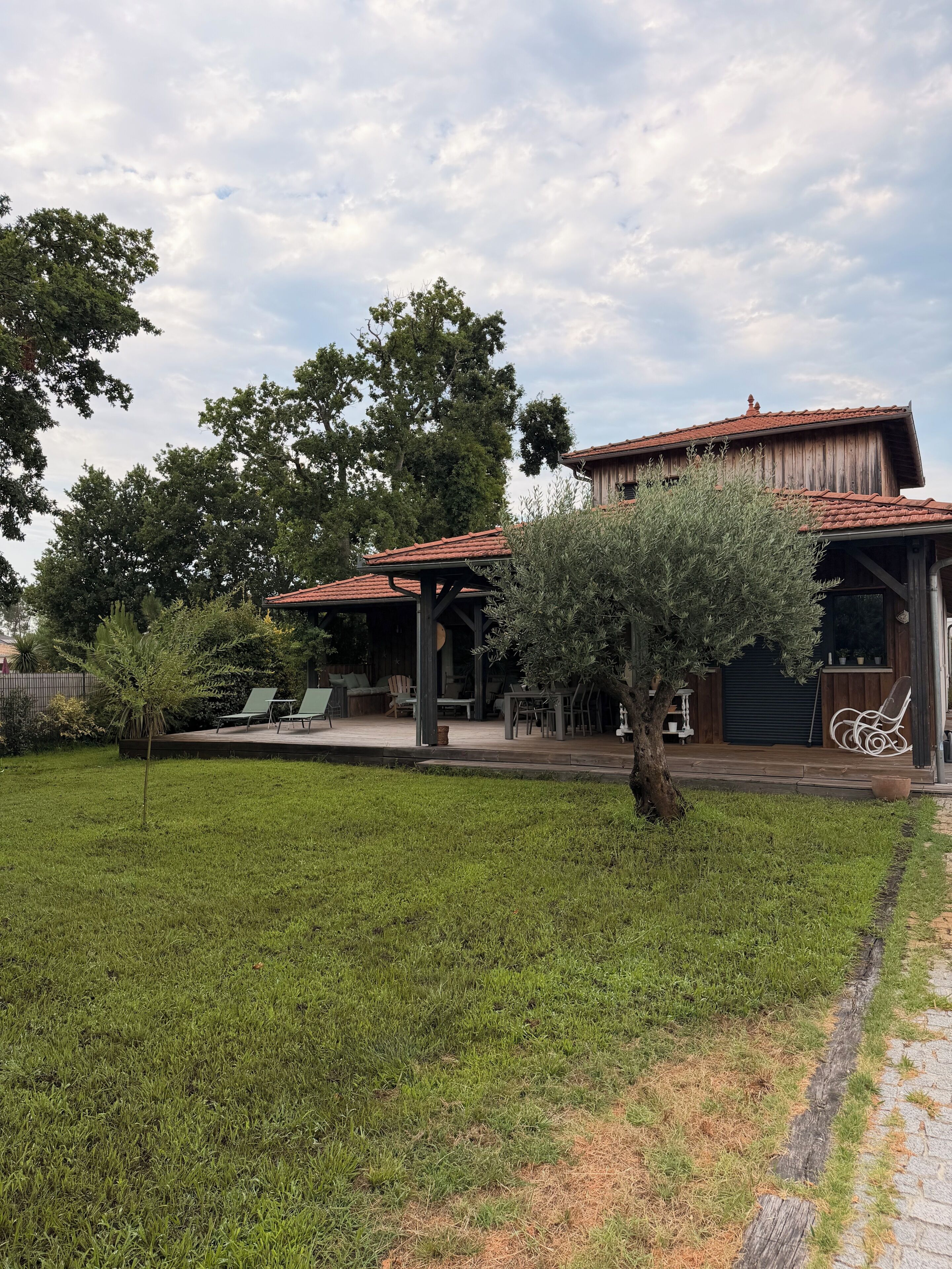 Een huis met een patio, buitenmeubels en een overdekte veranda.