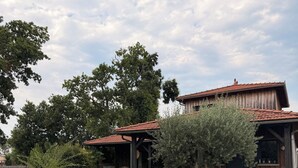 Una casa con patio, mobiliario exterior y porche cubierto.