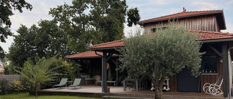 Een huis met een patio, buitenmeubels en een overdekte veranda.