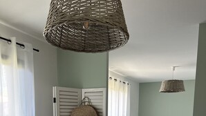 Un dormitorio con cama, una silla, un armario y una cesta colgante.