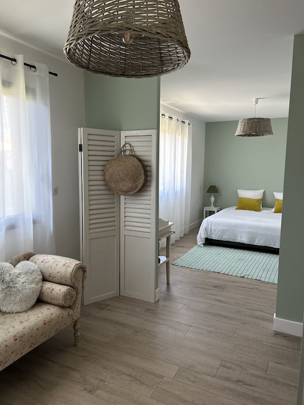 Un dormitorio con cama, una silla, un armario y una cesta colgante.
