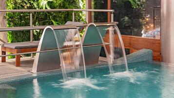 A pool with three water features and a bench.