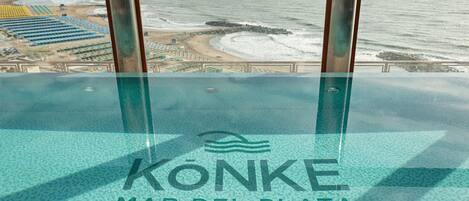 Una piscina infinita con vistas a la playa y al océano.