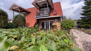 A two-story house with a red-tiled roof, a balcony, and a visible number '17' on the side. - Ebbe und Flut, Hannoversche Straße 17 OG, 27476 Cuxhaven- Sahlenburg (Cuxhaven- Sahlenburg)