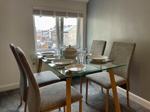 Enjoy meals in this dining area with a glass table and four comfortable chairs.