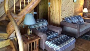 Eine Holztreppe mit einer Lampe und einem Sofa mit gemusterten Kissen.