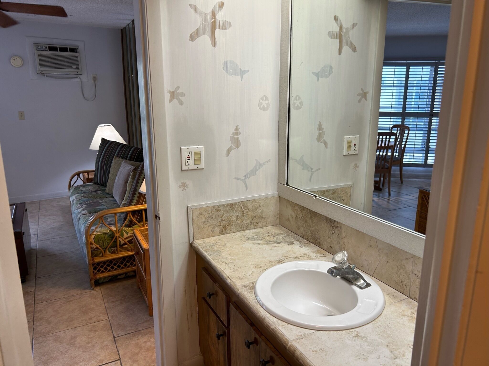 A bathroom with a white sink, a mirror, and a shower area.