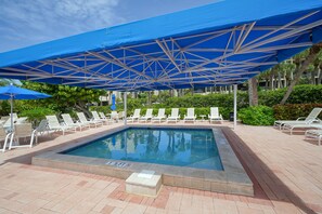 Relax by the pool surrounded by lush greenery and shaded areas.