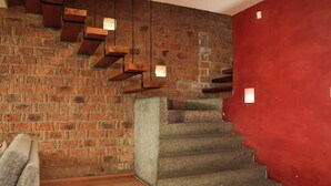 A staircase with a brick wall on one side and a red wall on the other, leading to an upper floor. - Valentin House, very spacious and cozy. (San Luis Potosí)