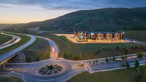 A modern building with a central courtyard, surrounded by roads and hilly terrain. - SpringHill Suites by Marriott Avon Vail Valley (Avon)