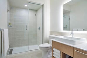 A modern bathroom with a glass-enclosed shower, a white toilet, and a sink with a wooden vanity. - SpringHill Suites by Marriott Avon Vail Valley (Avon)