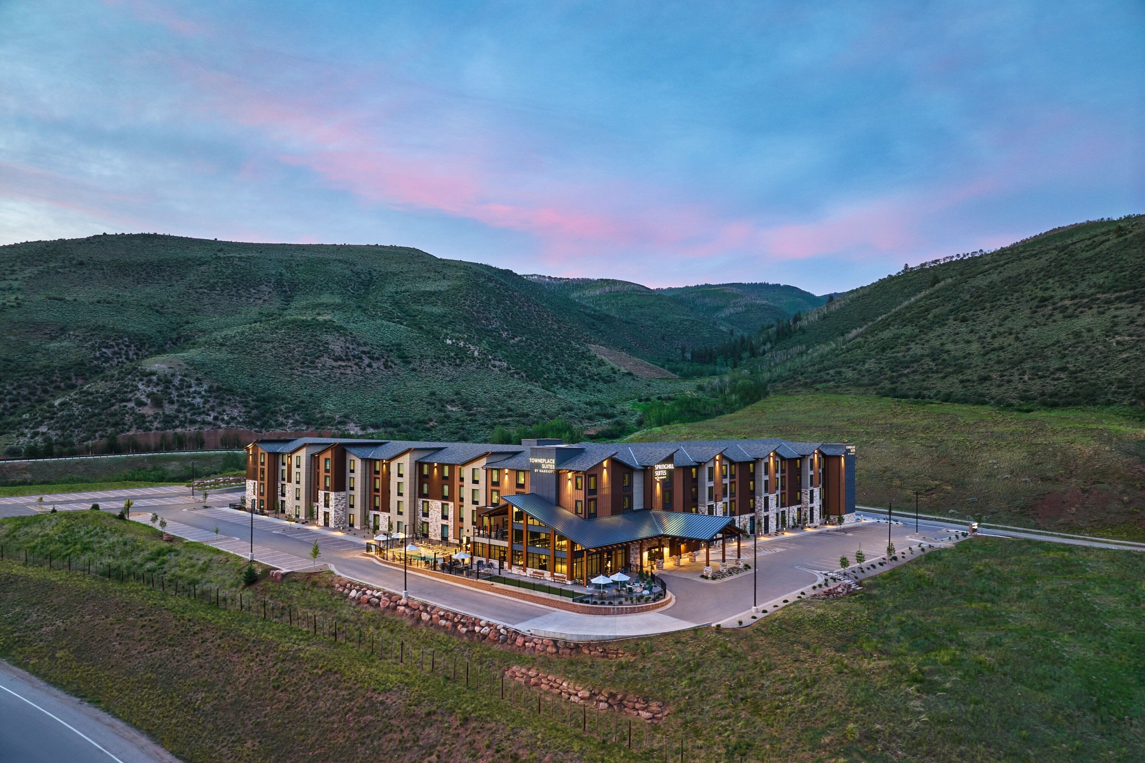 A modern hotel with a central courtyard, surrounded by hilly terrain.