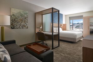 A hotel room with a bed, a desk, a chair, a sofa, a tray table, and a large window with a view. - Springhill Suites By Marriott Avon Vail Valley (Avon)