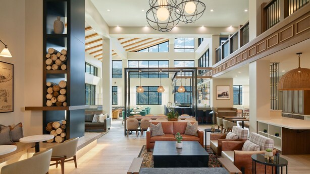 A spacious, well-lit interior with a high ceiling, large windows, and a variety of seating arrangements including sofas and tables. - SpringHill Suites by Marriott Avon Vail Valley (Avon)