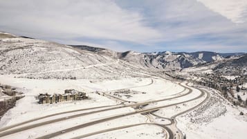 A snow-covered landscape with a multi-lane highway and a building complex with several structures.