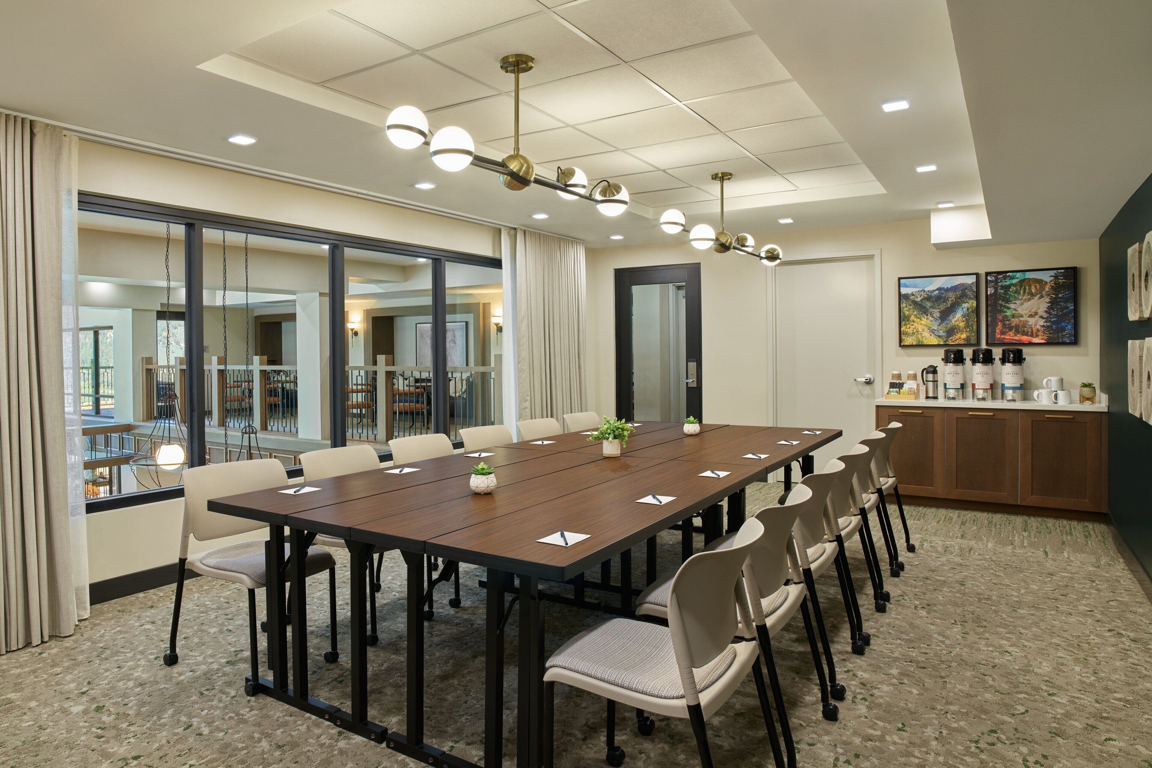 A conference room with a long table, chairs, and a ceiling light fixture.