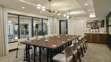 A conference room with a long table, chairs, and a ceiling light fixture.