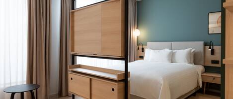 Una habitación de hotel moderna con cama, mesitas de noche, escritorio y una silla.