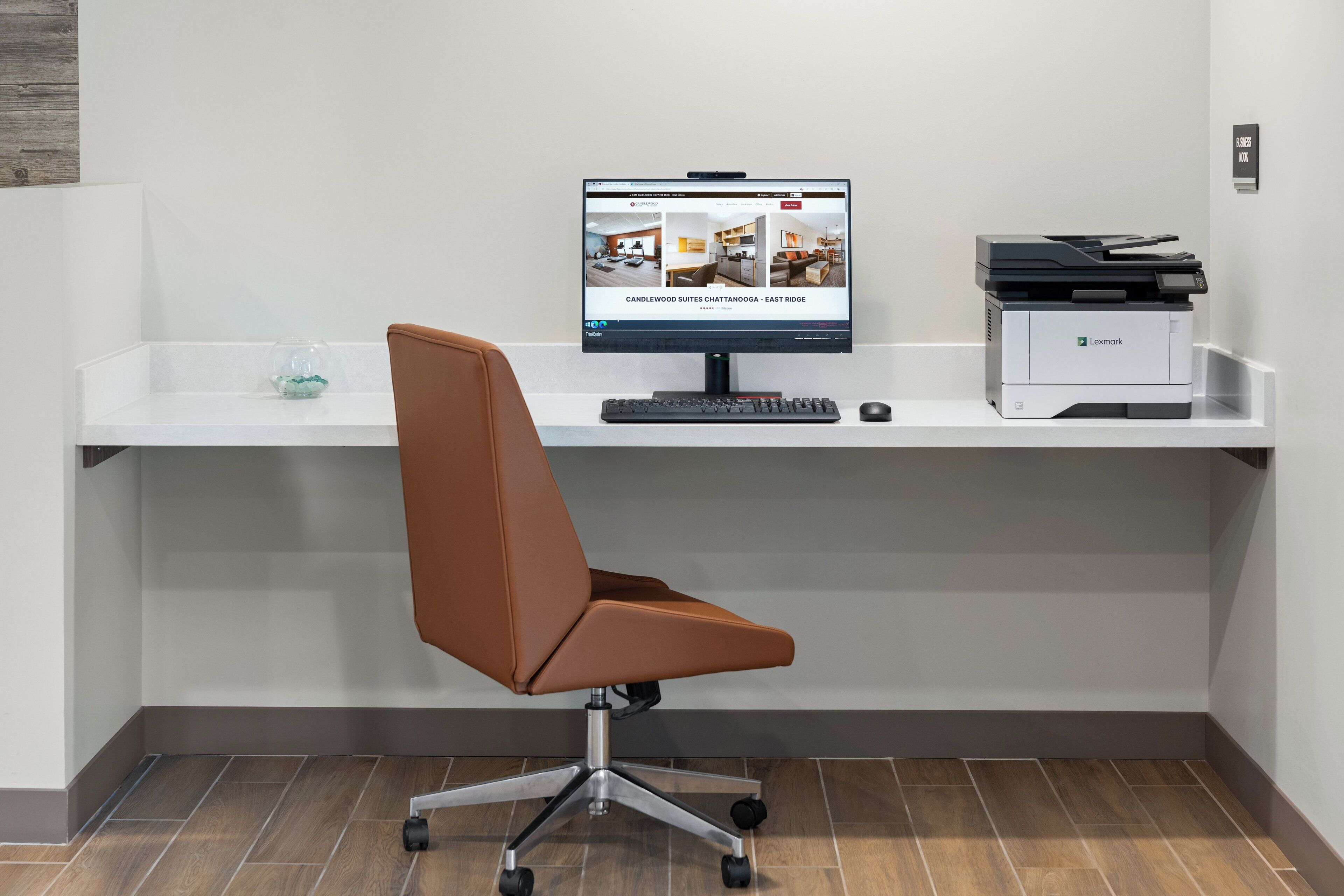 A modern office desk with a computer, keyboard, and printer.