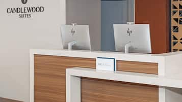Una mesa de recepción con un letrero que dice "IHG ONE REWARDS" y el logotipo de Candlewood Suites.