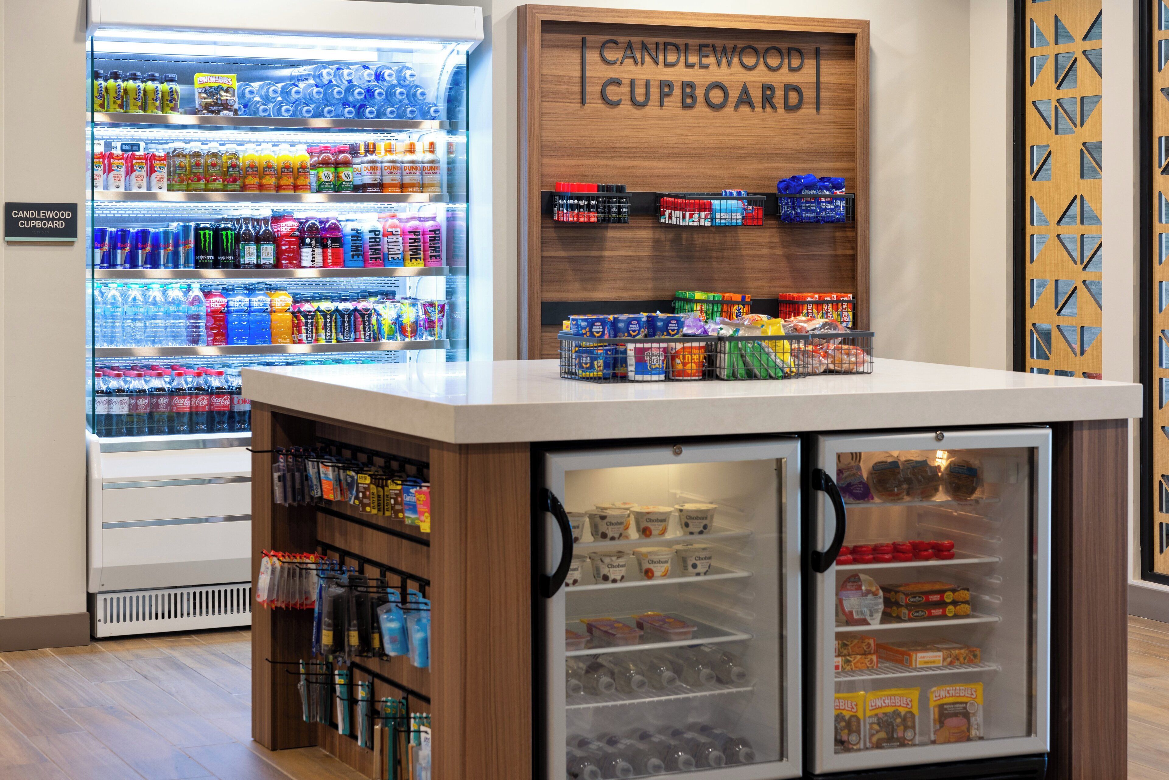 A beverage kiosk with a refrigerated display and a wooden counter.