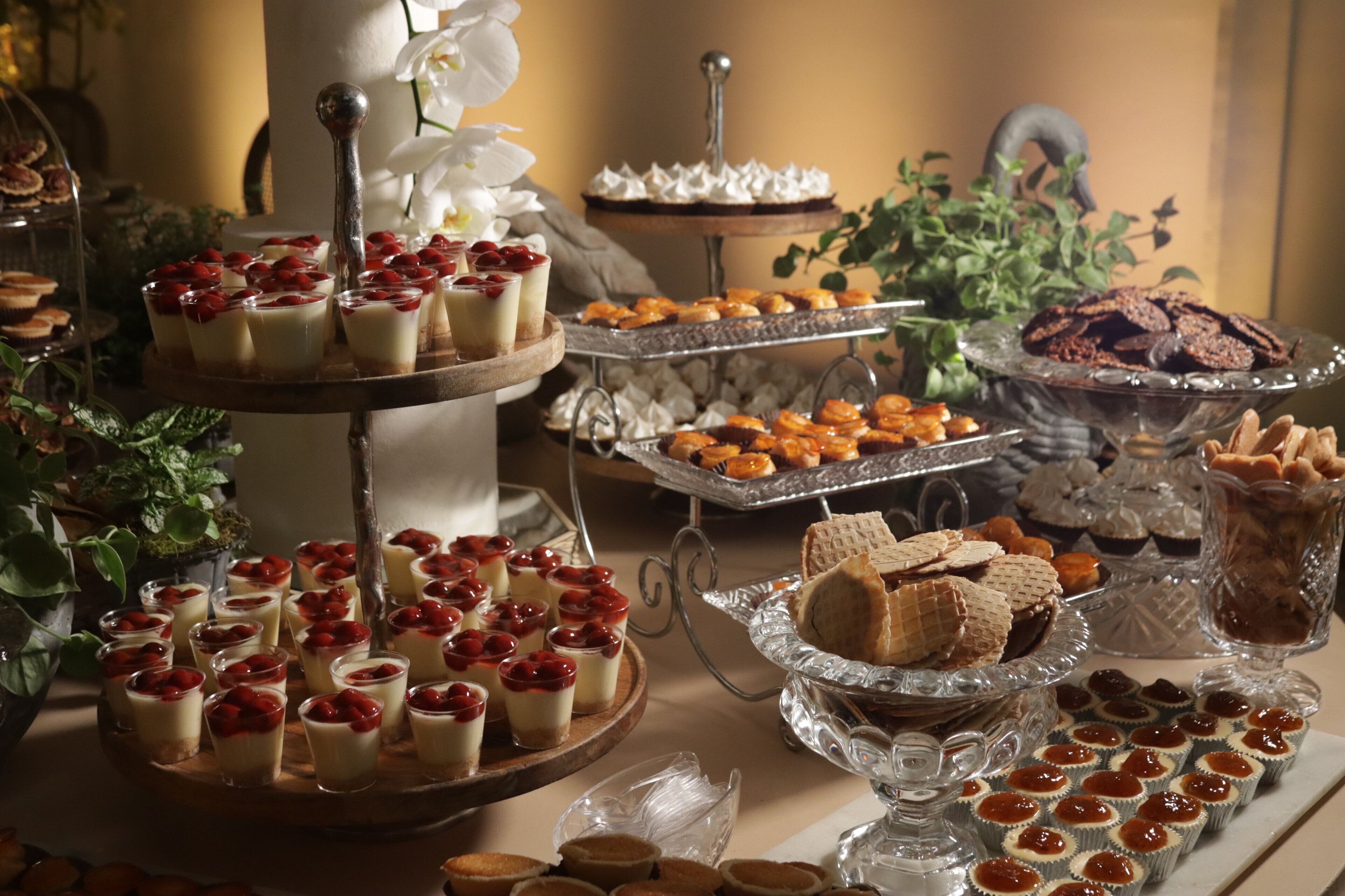 A buffet with various desserts including cupcakes, macarons, and pastries.