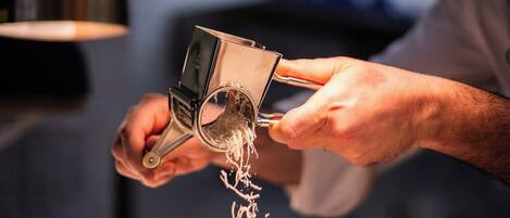 A person grating cheese over a dish.