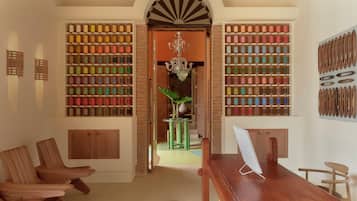 Une pièce avec un bureau en bois, des chaises et une bibliothèque remplie d’objets colorés.