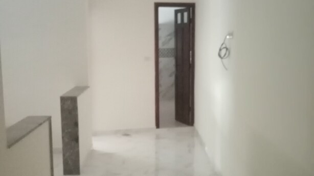 A hallway with a marble floor, a door at the end, and a small shelf on the left wall. - Belle Appartement Dans les Hauteurs de el Hajeb Proche de la Ville e Centre (El-Hajeb)