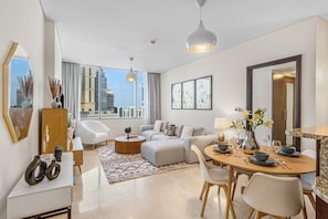 Enjoy a city view from the large window in this stylish living room, featuring a comfortable seating area and dining space.