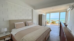 Relax in a spacious room with a large bed, balcony, and stunning sea views.
