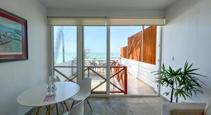 Enjoy the stunning sea views from the balcony, featuring a round table and chairs, and a beautiful framed picture on the wall.