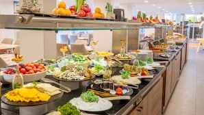Un bufé con diferentes opciones de comida y un área de estar al fondo.