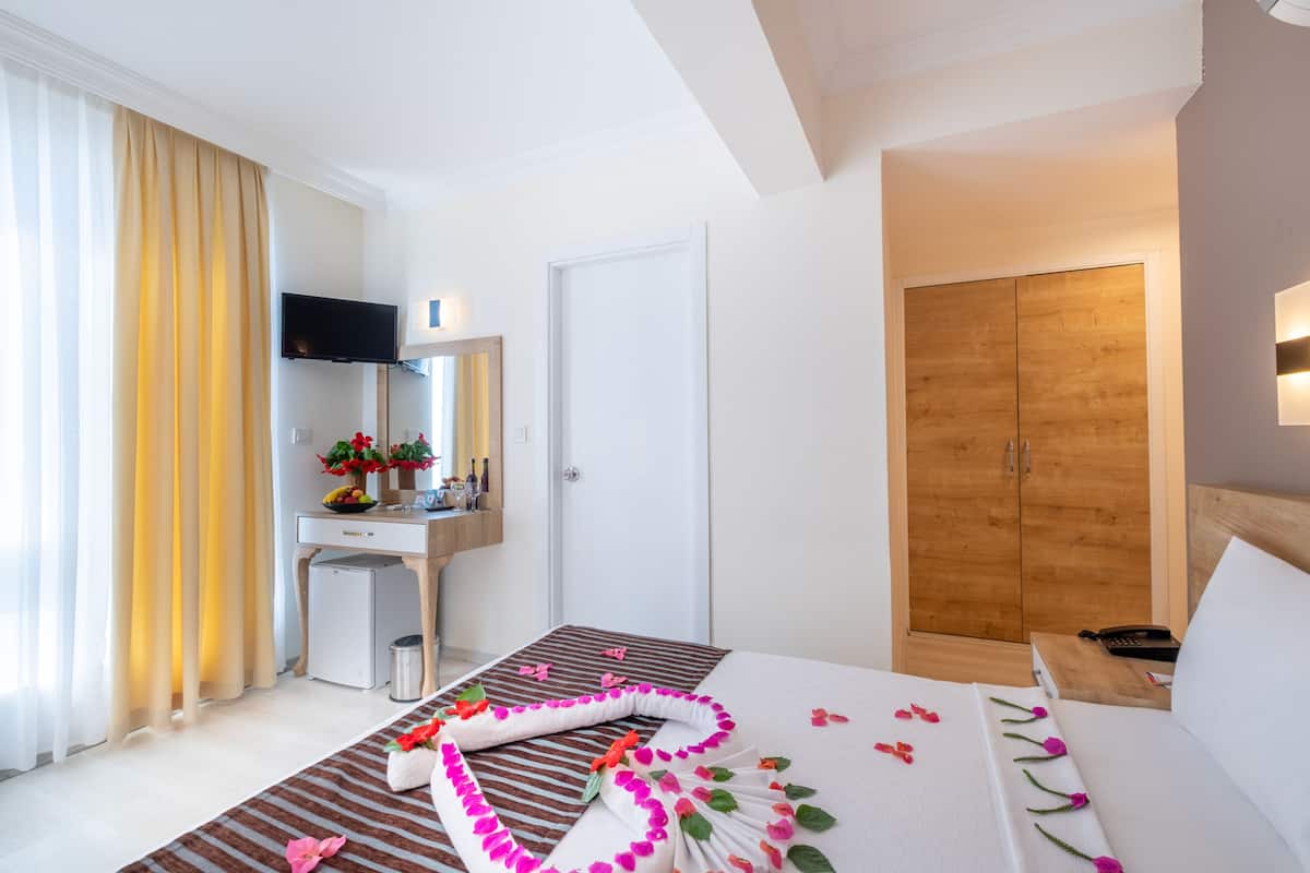 Une chambre d’hôtel équipée d’un lit, d’un bureau, d’une armoire et d’un téléviseur.
