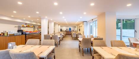 Enjoy communal dining in a spacious area with long tables and comfortable seating.