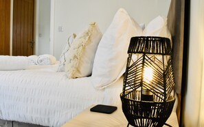 A neatly made bed with white linens and a black smartphone on a bedside table. - *Luxury Apartment 2min from Carlisle City (Carlisle)