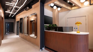 Un comptoir d’accueil avec un revêtement en bois, un téléviseur à écran plat et une lampe jaune.