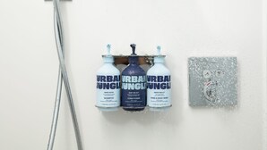 Una ducha con tres productos Urban Jungle: champú, acondicionador y jabón de manos y cuerpo.