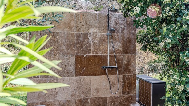 A shower area with a tiled wall, a handheld showerhead, and a built-in water heater. - Villa Triptyque - Avec piscine et grand jardin (Villecroze)