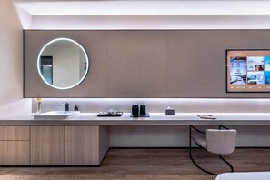 Ein modernes Badezimmer mit einem großen Spiegel, einem Waschbecken und einer Toilette.