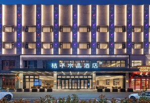 Une façade d’hôtel au design moderne, caractérisée par de nombreuses fenêtres et une entrée imposante.