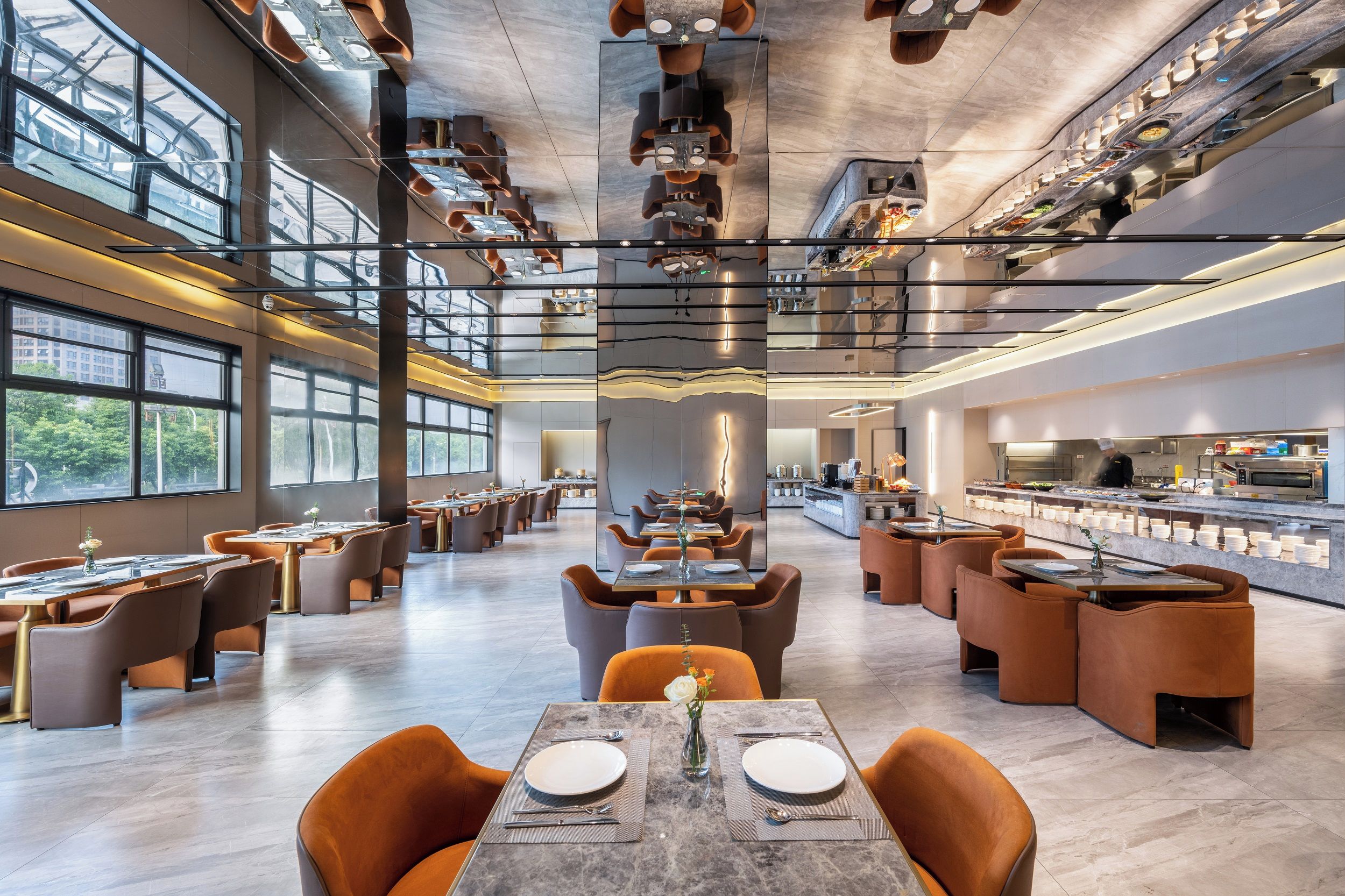 A modern restaurant with high ceilings, large windows, and a central bar area.