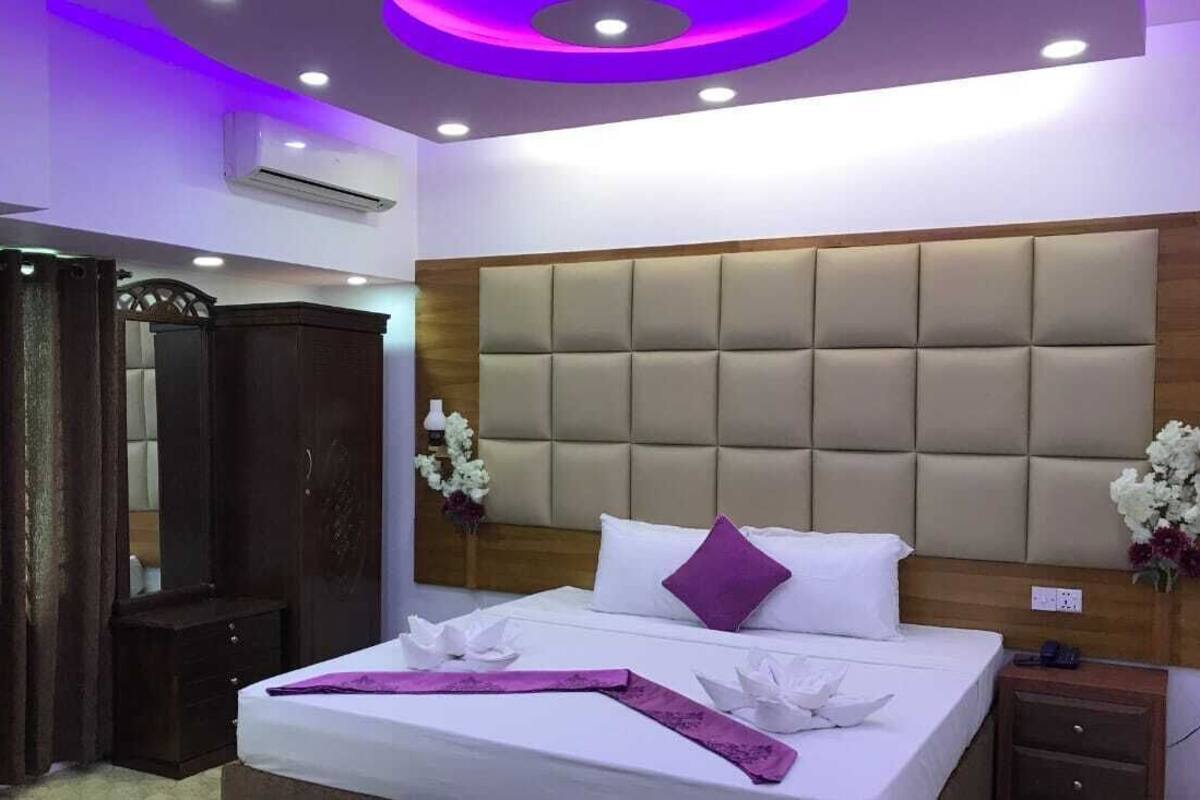 Ein Hotelzimmer mit einem großen Bett, einem Holzkopfstück und einem Nachttisch.