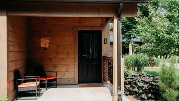 A wooden building with a black door marked with a 'B'.