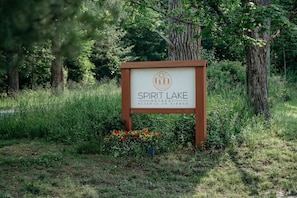 A sign for Spirit Lake Retreat Reserve on Airbnb, surrounded by trees and grass.