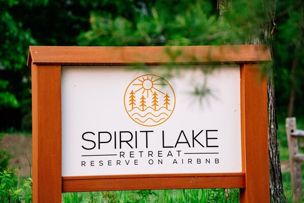 Letrero de Spirit Lake Retreat Reserve en Airbnb, con un logotipo que muestra un sol, árboles y olas.