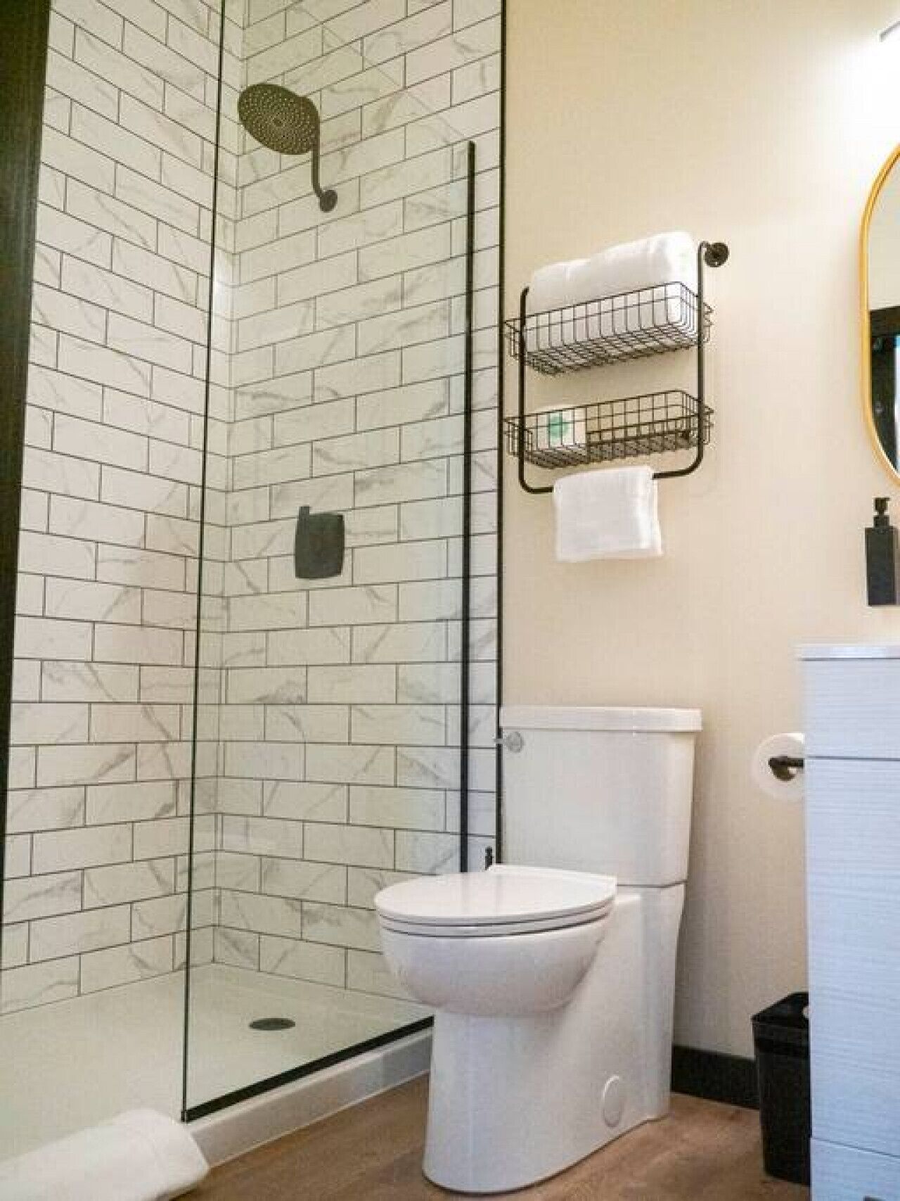 Une salle de bain avec une douche à parois de verre, des toilettes et un porte-serviettes avec une serviette.