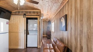 A wooden interior with a laundry area, a bench, and a ceiling fan. - Tiny cabin on 10 acres with pond (Albertville)