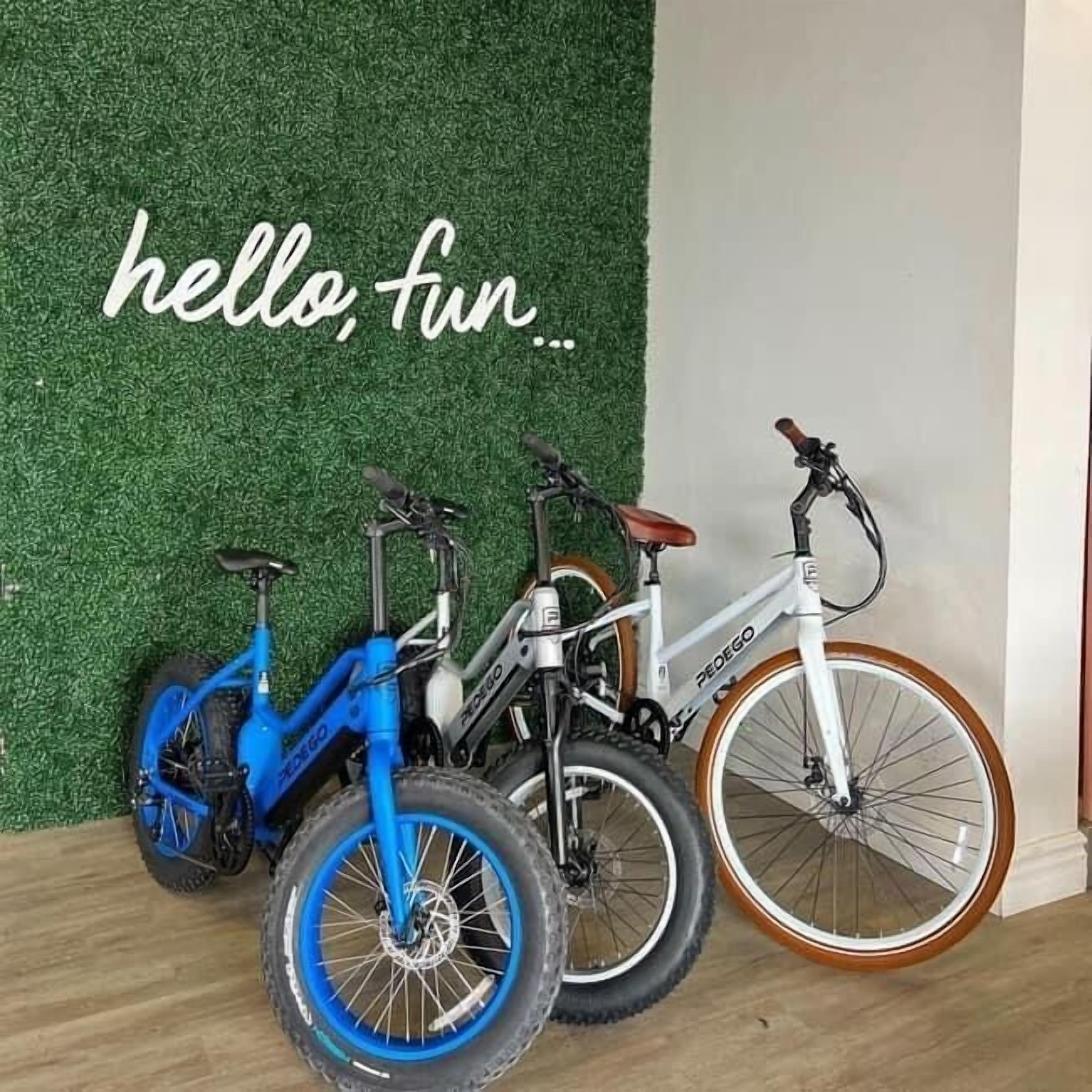 Three bicycles against a green wall with the text "hello, fun...".