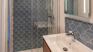 A modern bathroom with a glass-enclosed shower, a white sink, and a mirror with built-in lighting. - Tarka Summerhouse - Four Bedroom House, Sleeps 8 (Woolacombe)